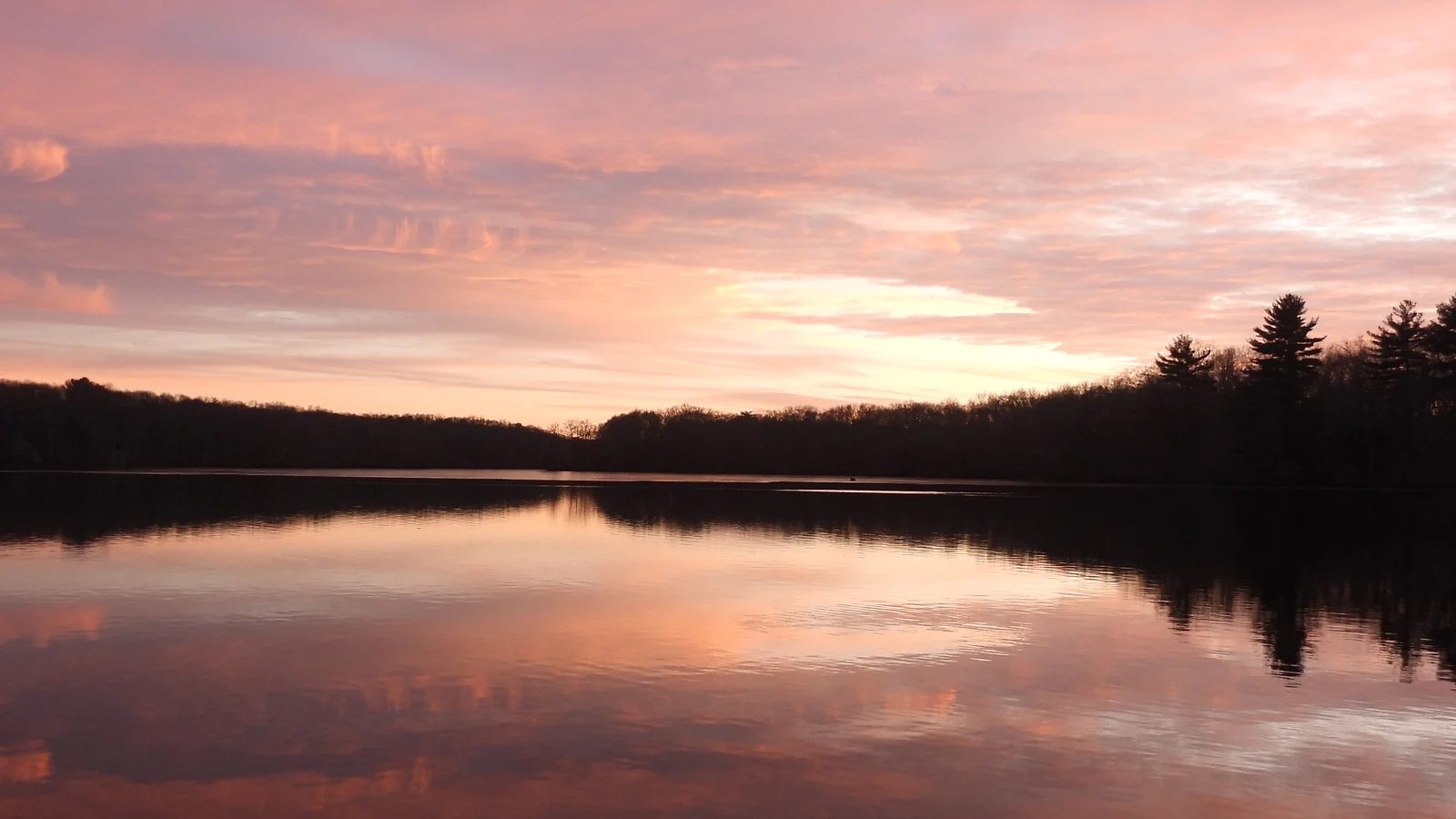 Warm sunset light across a quiet lake.